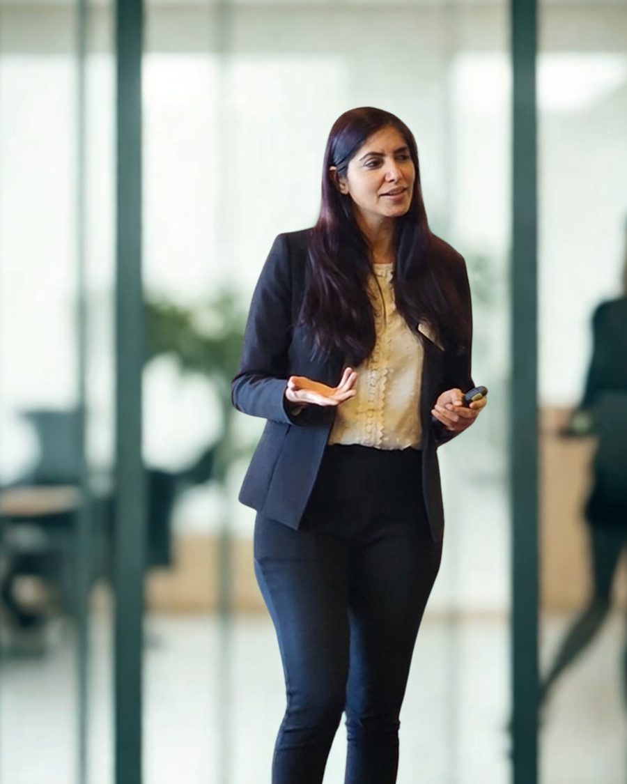 Kanika Vasudeva, LinkedIn strategist and corporate trainer, presenting to a team in an office.